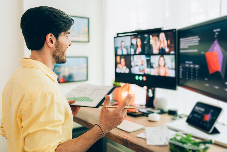 a young man attending a webinar at a desk
